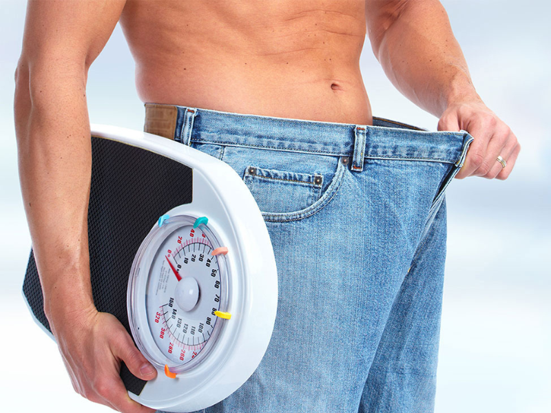 A man grips a weight scale, showcasing the tool used for determining weight measurements.